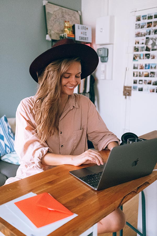 woman-entrepreneur-home-office-desk-hat-laptop
