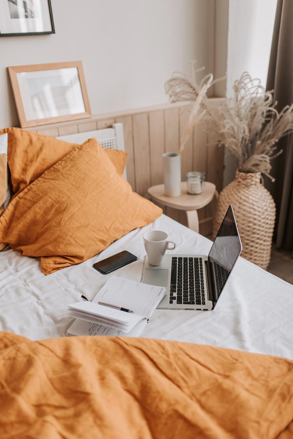 woman-entrepreneur-laptop-bed-home
